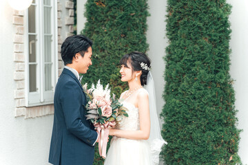結婚式で結婚式場の庭でブーケを持つ新郎新婦（ガーデンウェディング）
