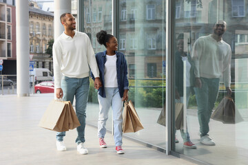 Family shopping. Happy couple with purchases near mall outdoors