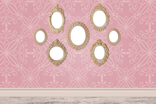 Blank vintage frames hanging on pink patterned wall. Mockup for design