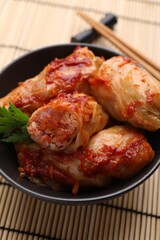 Delicious stuffed cabbage rolls cooked with homemade tomato sauce on table, closeup