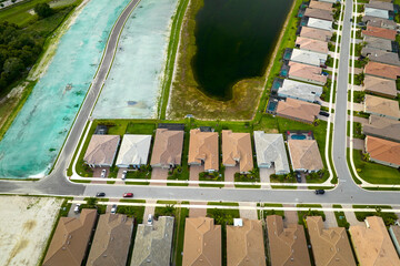 Aerial view of real estate development with tightly located family houses under construction in Florida closed suburban area. Concept of growing american suburbs