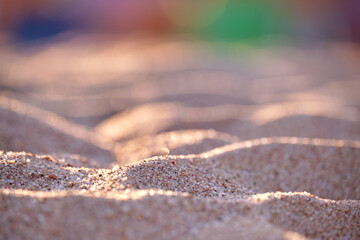 Close up of clean yellow sand surface covering seaside beach illuminated with evening light. Travel and vacations concept