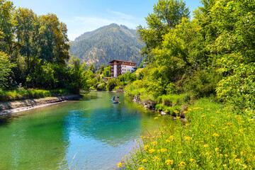 Visitors float the calm waters of the Wenatchee River as it runs past Blackbird Island and the touristic Bavarian themed resort town of Leavenworth, Washington USA on a hot summer day. © Kirk Fisher