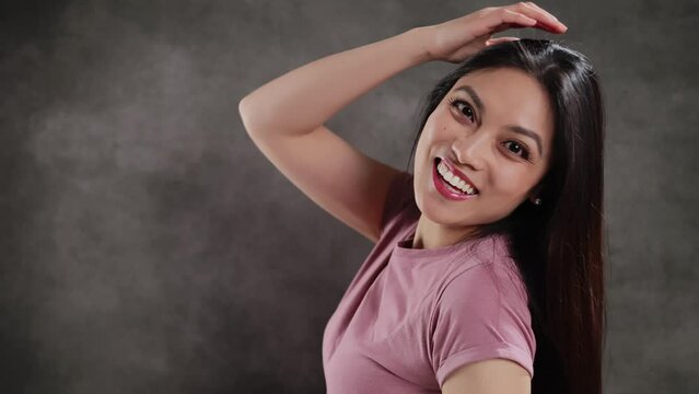 Young Asian woman in a studio doing some gestures for a photo shooting - extreme slow motion