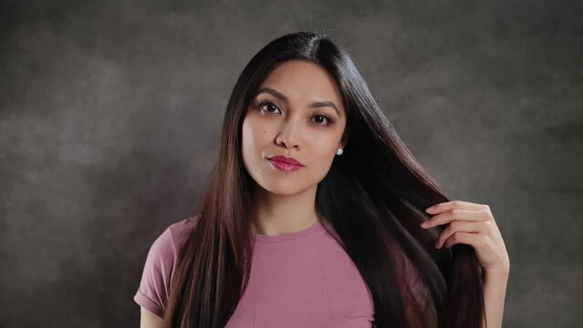 Young Asian woman in a studio posing for the camera - extreme slow motion