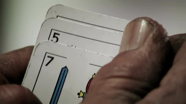 Man Hands Holding Three Truco Cards, Truco is a Trick-taking Card Game Popular in Argentina. Close Up. 4K Resolution.