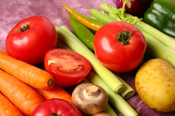 Different fresh vegetables on purple background