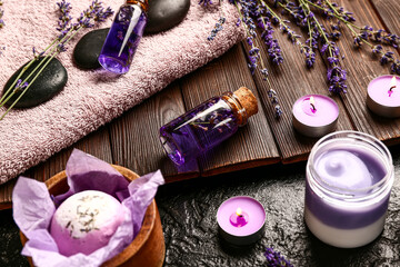 Composition with cosmetic products, spa accessories and lavender flowers on dark background, closeup