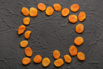 Obraz na płótnie Canvas Frame made of tasty dried apricots on black background