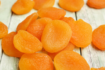 Tasty dried apricots on green wooden background
