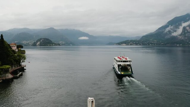 Aerial shot of a ferry leaving Varenna to transport commuters on Lake Como.
