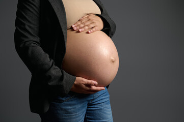 Cropped View. Gravid female, expectant mother gently holding her pregnant belly , isolated over...