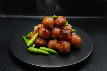 Hot small sausages topped with fresh chili peppers.
