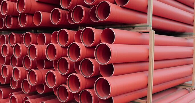 warehouse of a new orange plastic sewer pipe in the open air