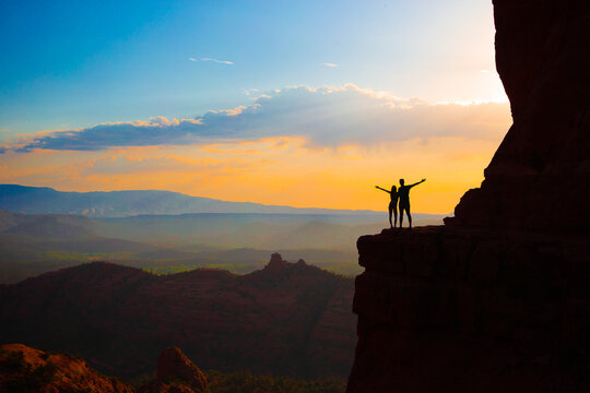 Silhouette of father and his daughter on the trail at Cathedral Rock at sunset in Sedona. The colorful sunset over Sedona's Cathedral Rock landmark.