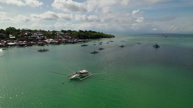 Village de p&ecirc;cheurcolor&eacute; sur pilotis vu du ciel semblable &agrave; un bidonville au bord de la mer avec les bateau de p&ecirc;cheurs dans l'eau bleue sur l'ile de Panglao, &agrave; c&ocirc;t&eacute; de Bohol, aux Philippines, Asie