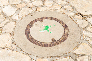 A green frog is painted on a manhole cover in the famous artists village Ein Hod near Haifa in northern Israel