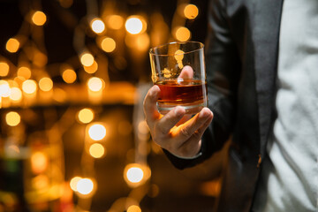 Businessman sitting and holding glass of whiskey