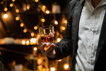 Businessman sitting and holding glass of whiskey