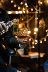 Businessman sitting and holding glass of whiskey