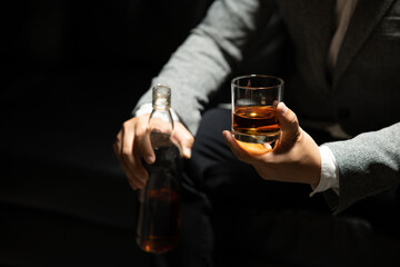 Businessman sitting and holding glass of whiskey