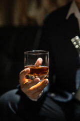 Businessman sitting and holding glass of whiskey