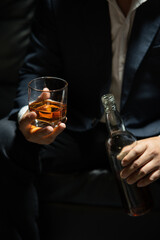 Businessman sitting and holding glass of whiskey