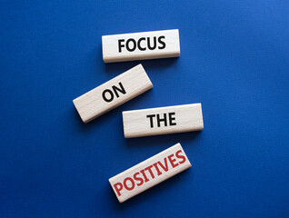 Focus on the Positives symbol. Concept words Focus on the Positives on wooden blocks. Beautiful deep blue background. Business concept. Copy space.