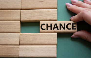 Chance symbol. Concept word Chance on wooden blocks. Businessman hand. Beautiful grey green...