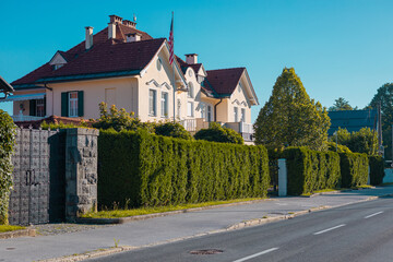 Home of american ambassador in Slovenia, Ljubljana on a summer day. Outer part of a house in Rozna dolina visible from the public street, no traffic, flag not waving.