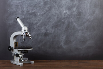 Back to school - microscope on the desk, Education concept. Blackboard background - 625778338