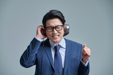 Middle-aged man wearing a headset and listening to music on his smartphone