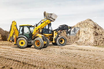 Obraz premium Modern construction machinery at a construction site in a quarry. Powerful modern equipment for earthworks. Rental of construction equipment. Excavator, dump truck, bulldozer, loader.