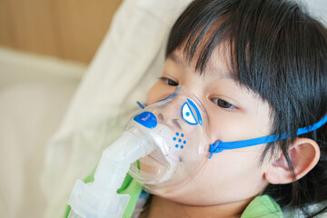 Sick little asian girl inhalation with nebulizer for respiratory treatment