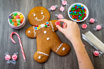 The girl decorates the Gingerbread Man. Christmas time.