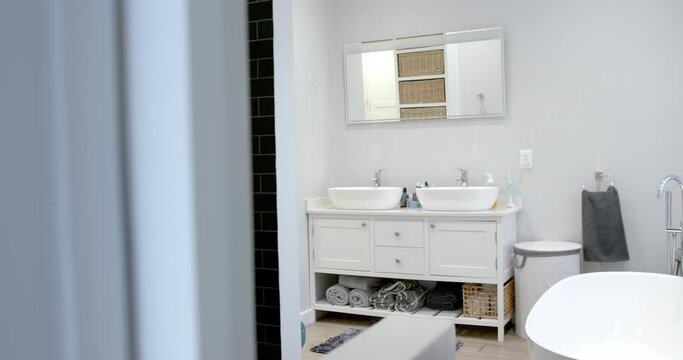 General view of bathroom with bathtub at home, mirror and washbasin, slow motion