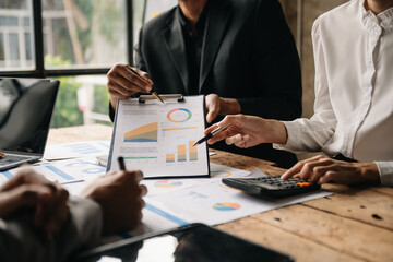 Businessman and team analyzing financial statement Finance task. with smart phone and laptop and  tablet. Wealth management concept.
