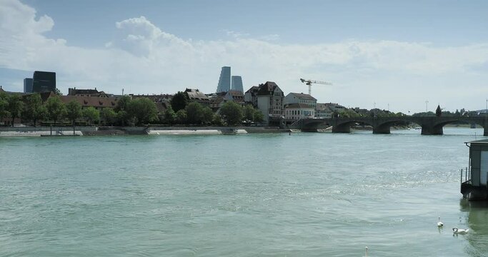 Swiss. Along the Rhine Promenade in Basel. The Middle Bridge (Mittlere Br&uuml;cke) . Right - Medieval town and Cathedral Basel. Left - Klingental museum, kHaus and Roche Tower on horizon
