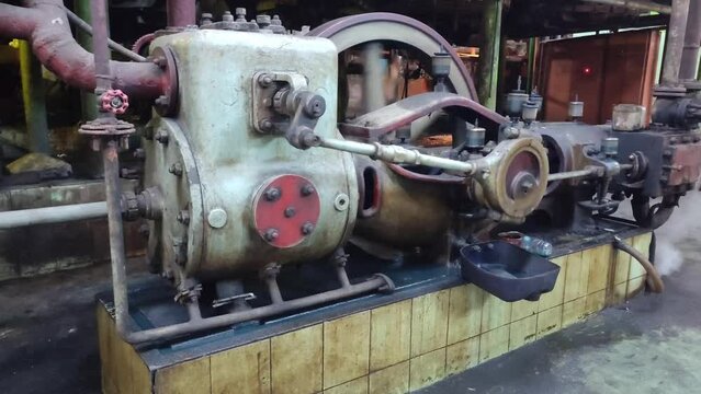 Steam engine driving an air compressor in a sugar industry factory.