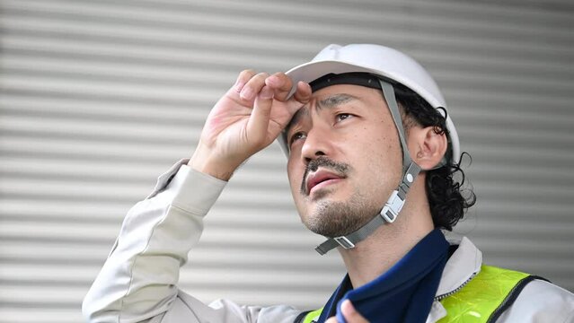 Workers at a construction site, man sweating in work clothes, video of Heat stroke prevention also be safe.
