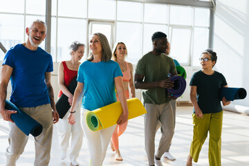 Group of senior athletes raise hands to ceiling at workout