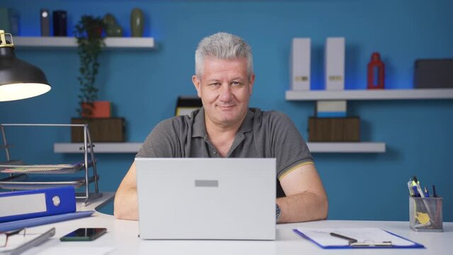 Home office worker man looking smugly at camera.