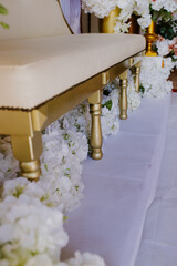 Wedding detail. Banquet. Decorated by flowers and greenery and lounge zone including chairs.