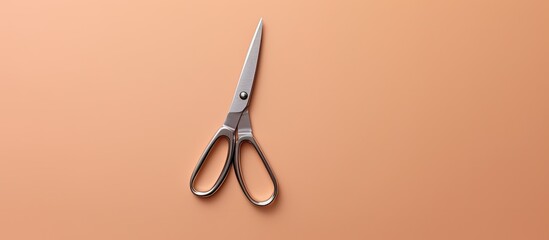 Photo of a pair of scissors on a table with copy space - obrazy, fototapety, plakaty