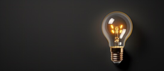 Photo of a glowing light bulb on a dark background with copy space