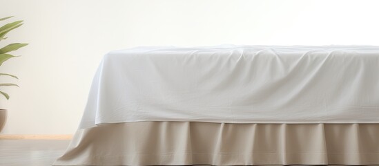 Photo of a neatly made bed with a touch of greenery from a potted plant with copy space