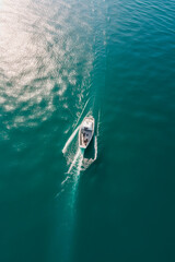drone shot of a small boat directly from above facing a huge shark. Ocean