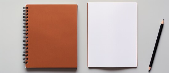 Photo of a notebook and pencil on a blank background with copy space