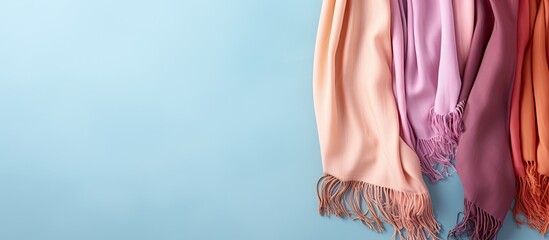Photo of a vibrant multicolored scarf hanging on a blue wall with plenty of copy space with copy space