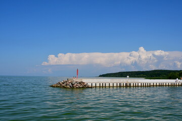 A view of a long jetty, marina, or platform made out of concrete located in the middle of a small,...